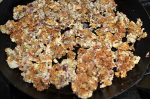 Sautéing the tofu vegetable mixture in skillet until golden.