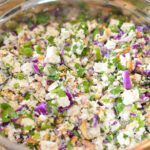 Hand chopped tofu, herbs and vegetables in a bowl.