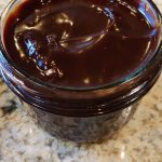 Chocolate sauce in a glass jar cooling.