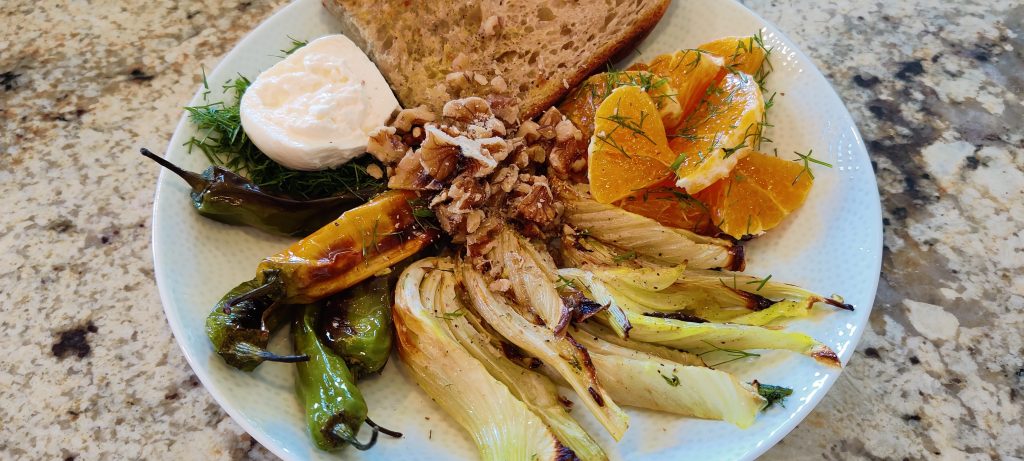 Roasted fennel slices, shishito peppers, sliced oranges plated with toasted bread and burrata cheese.