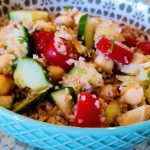 Mediterranean Tabbouleh salad with cucumbers, tomatoes and artichokes in a bowl.