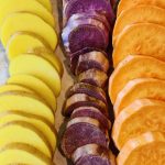 Sliced potatoes on a cookie sheet ready to roast.