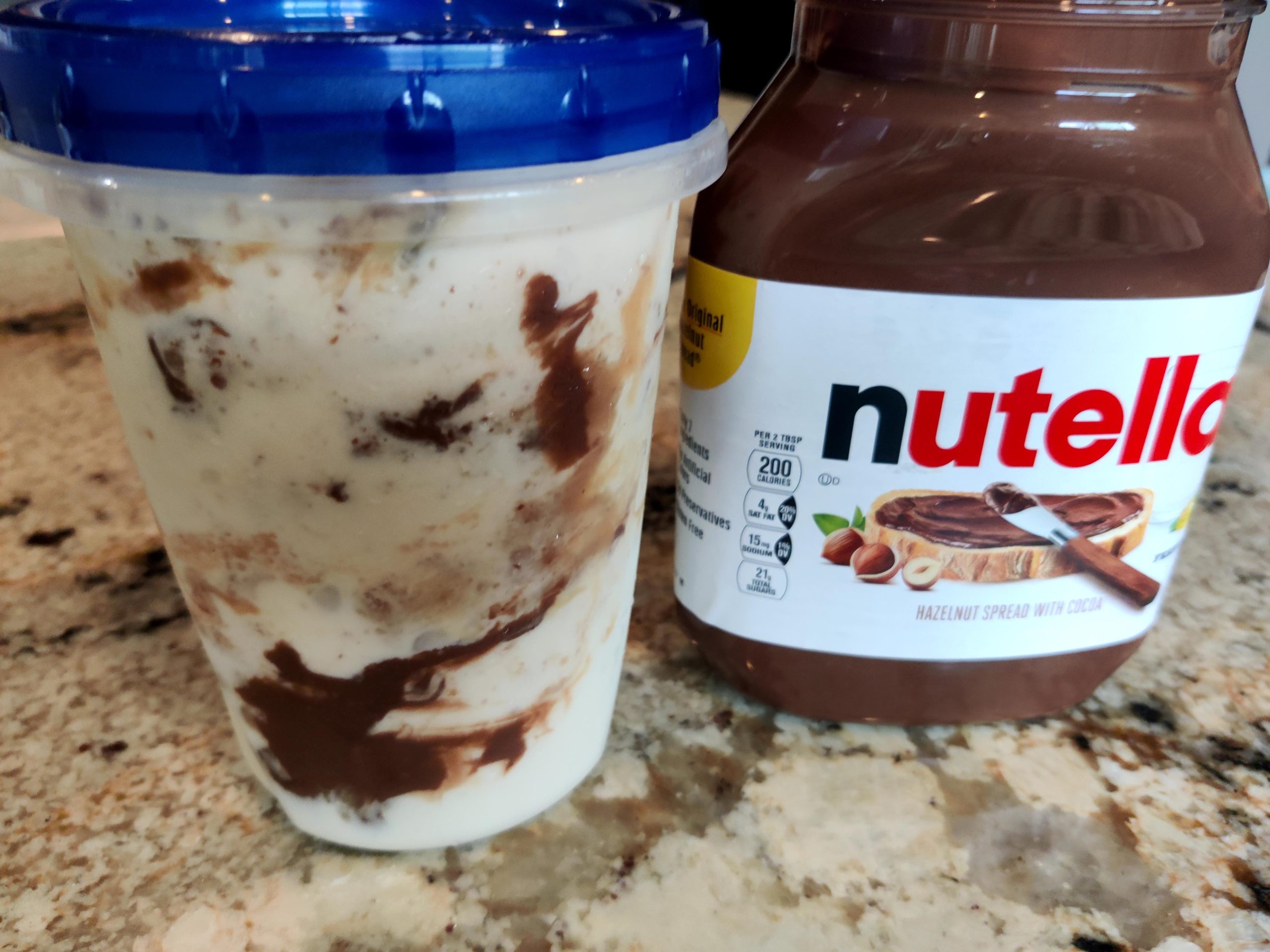Apple ice cream with peanut butter and Nutella swirls in jar ready to freeze.