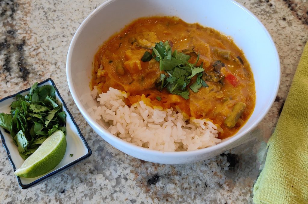 Thai pumpkin curry over rice with cilantro and lime