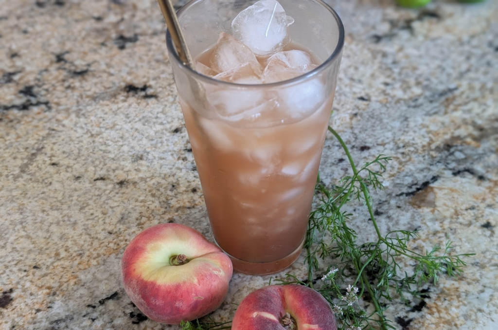 Peach fruit syrup summer drink in a glass.