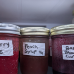 Fruit syrups and juices in jars in the fridge.